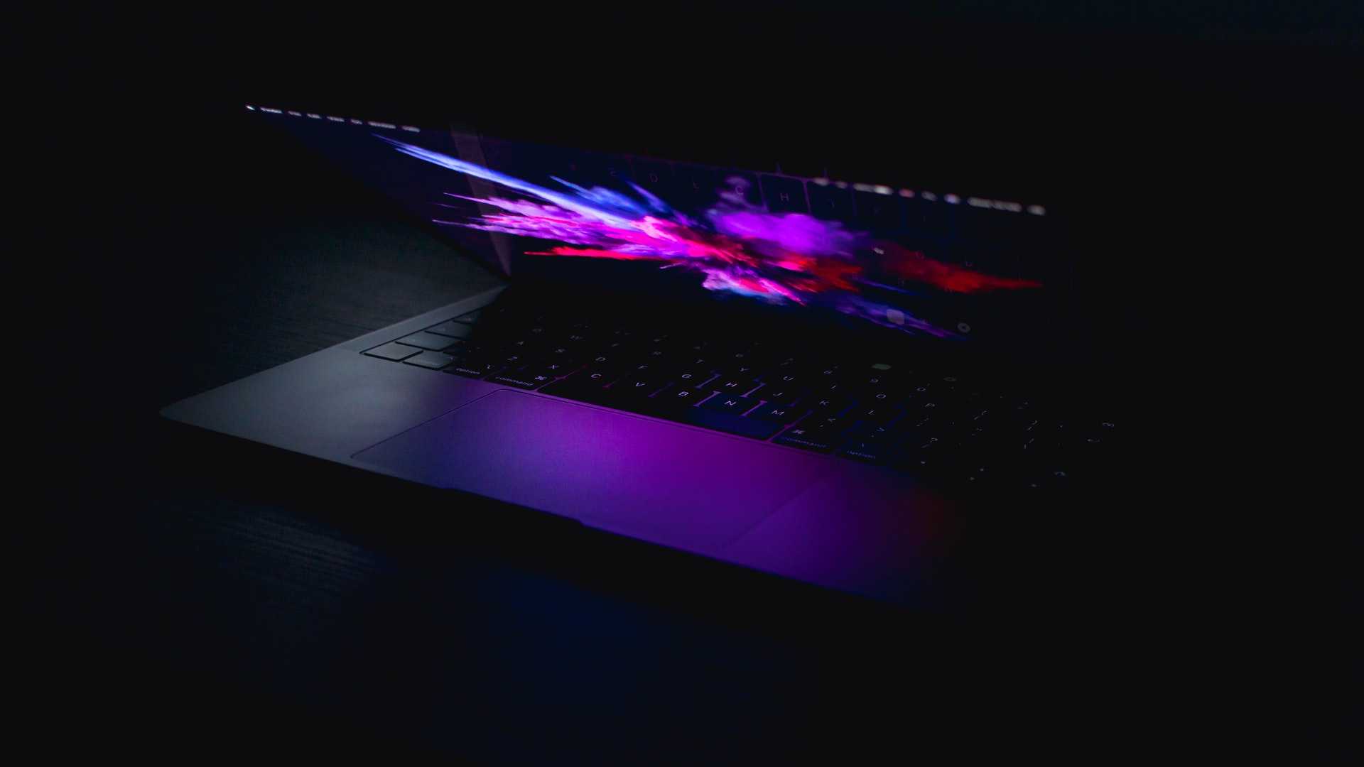 Macbook slightly open on a dark background